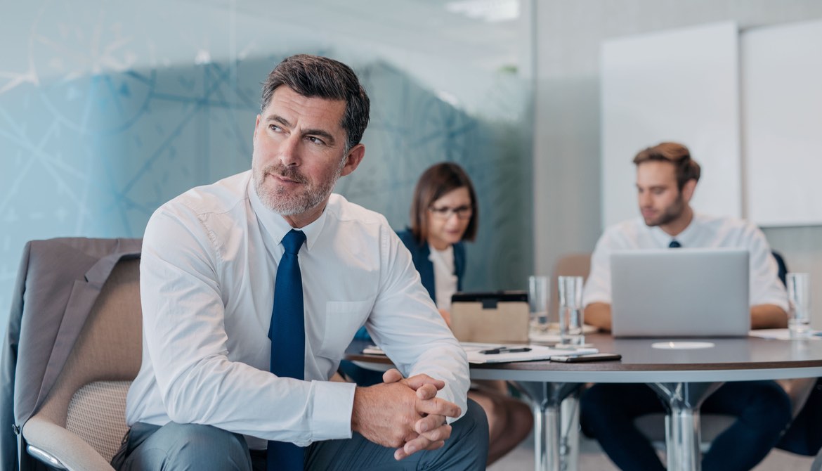 leader in front of other executives working at a table