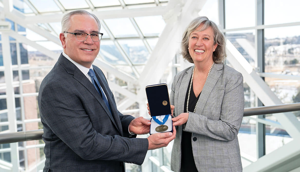 Elevations Credit Union CEO Gerry Agnes and Board Chair Kate Brown holding Malcolm Baldrige award medal