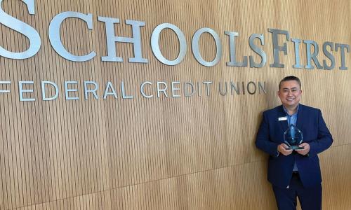 Alex Hsu of SchoolsFirst Federal Credit Union holding CUES Emerging Leader award