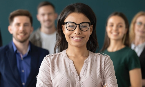 smiling young professional woman standing in front of group of other job candidates