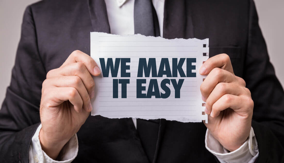 man holds sign that reads We make it easy