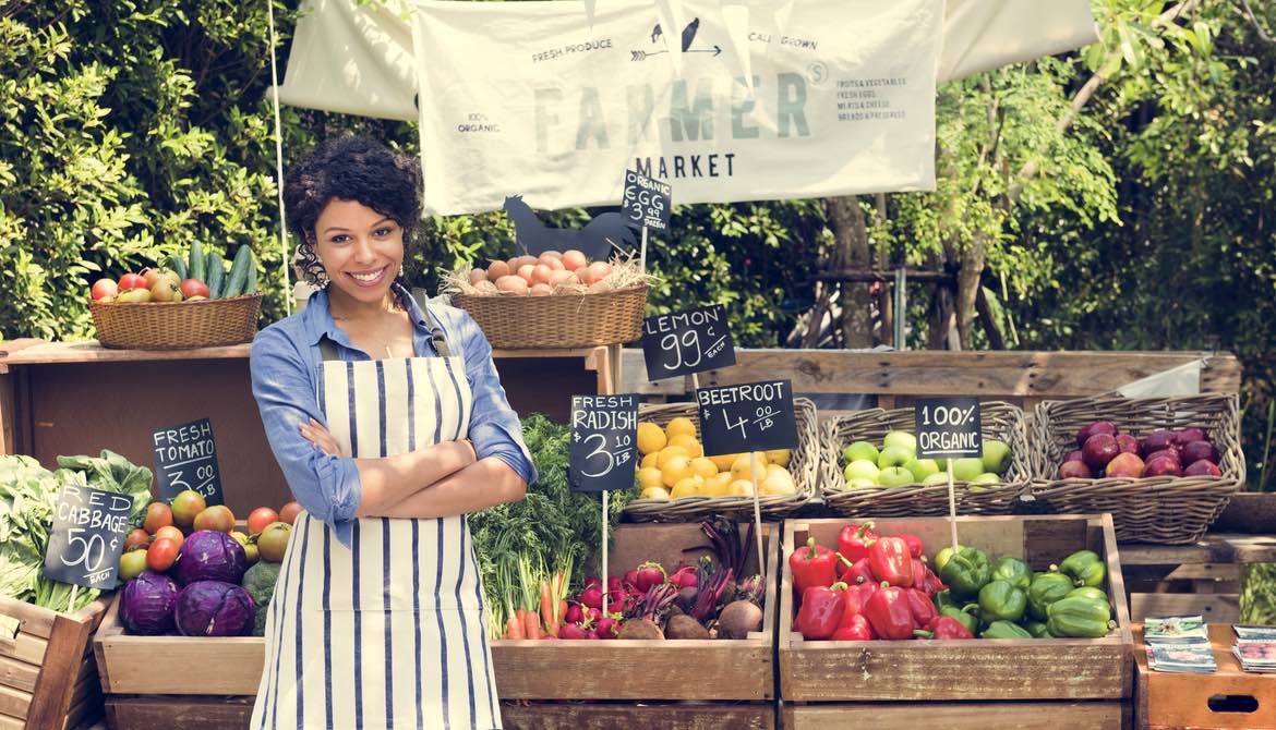 woman selling vegetables at a farmers market