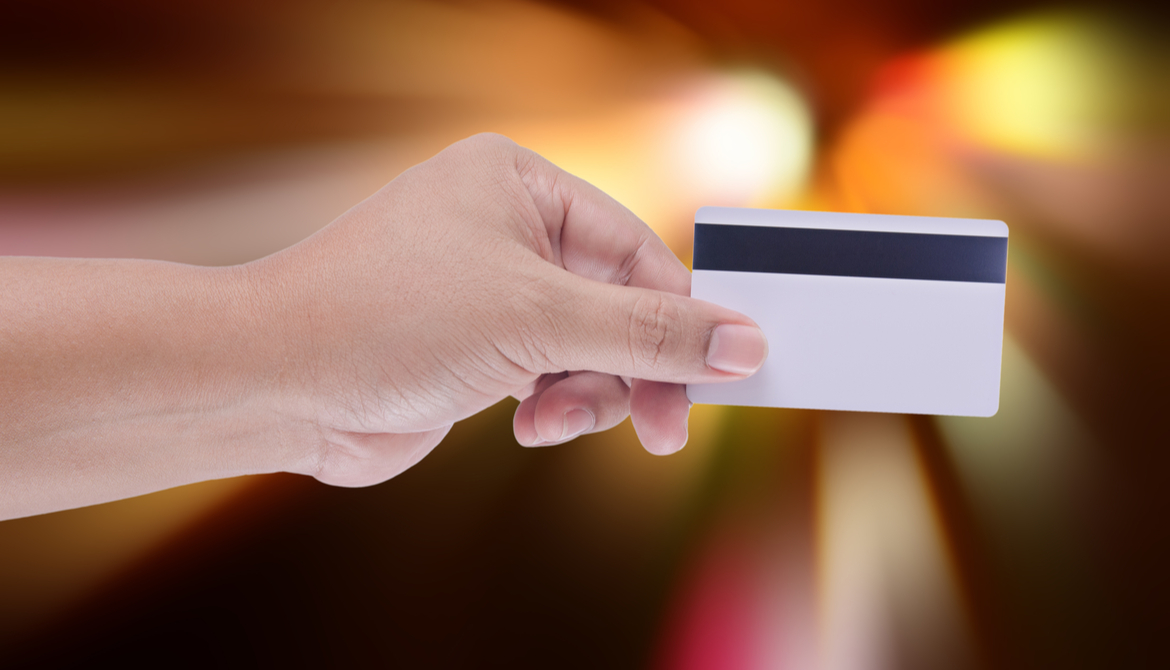 hand holding credit card with magnetic stripe showing