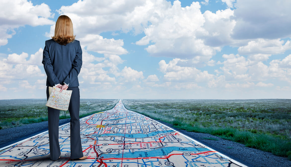 Professional woman stands on a map leading forward