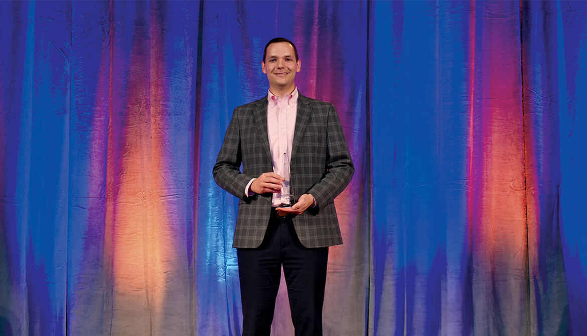 James Sackett on stage after accepting his award