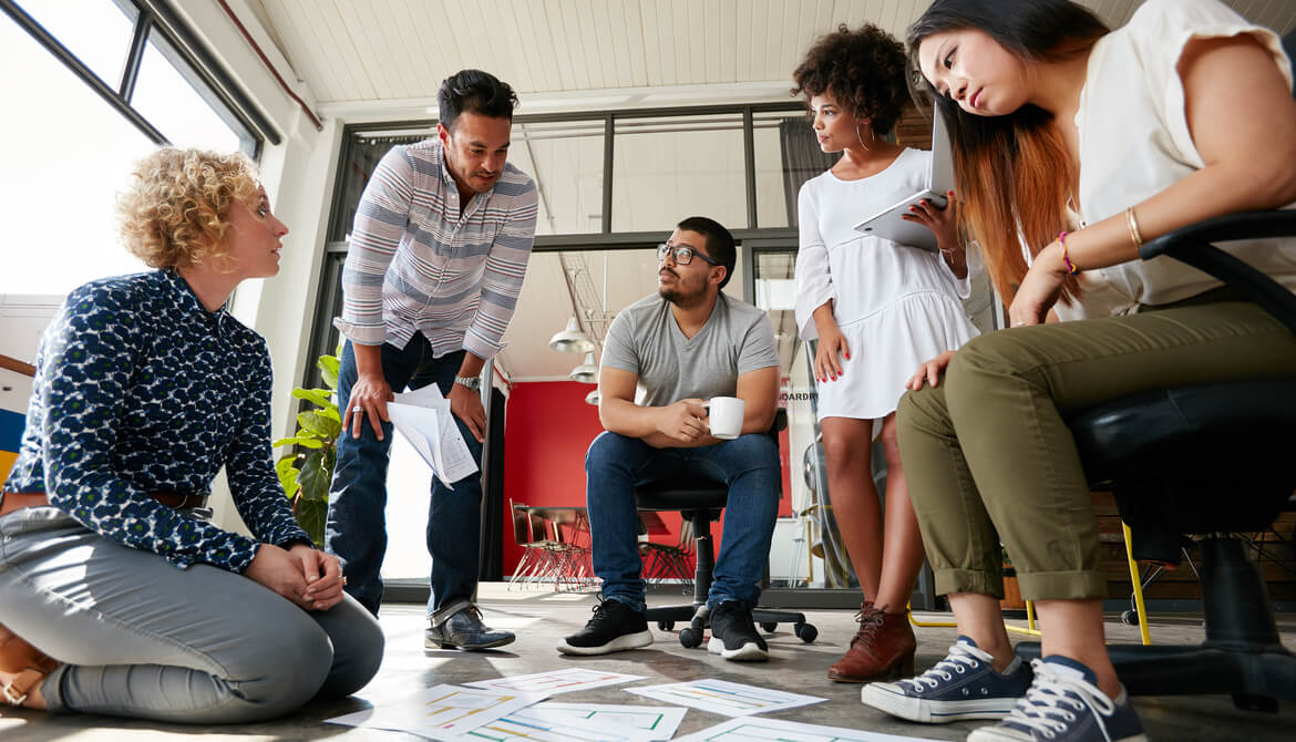 Group of young creative team going over some plans together