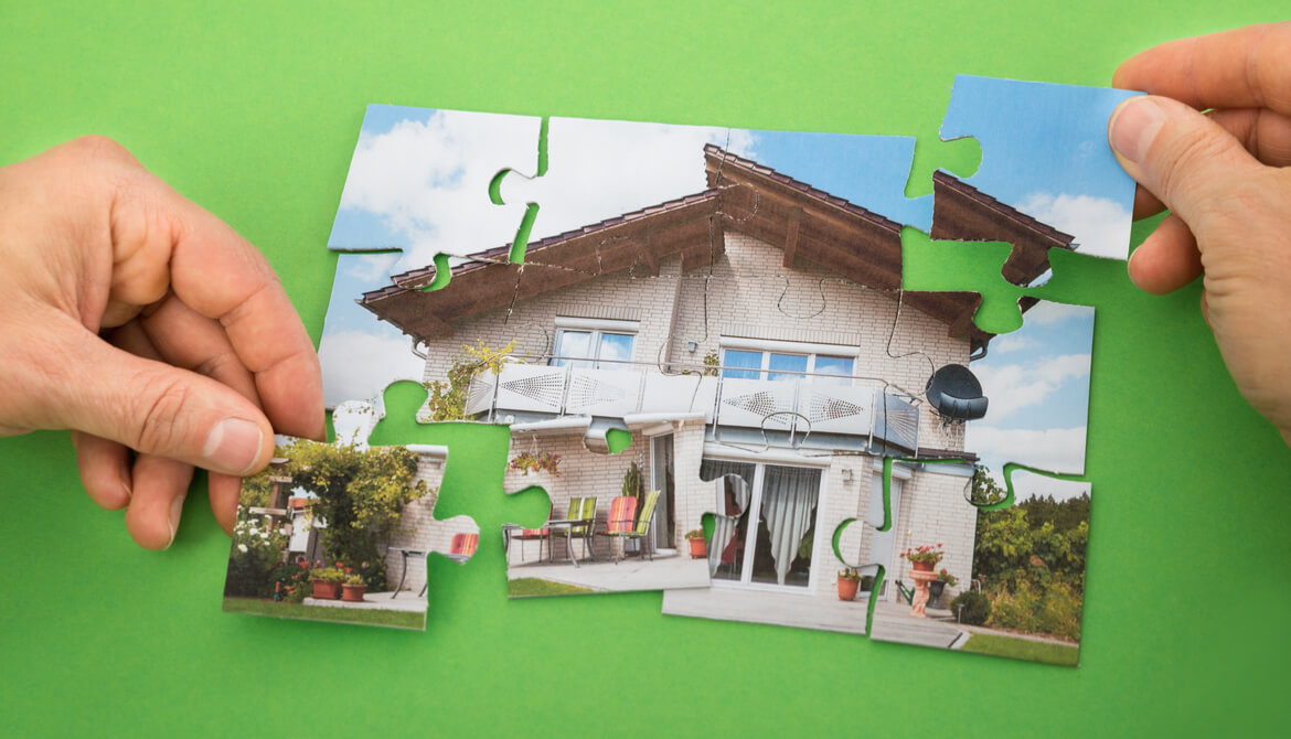 a couple puts together a puzzle of a house