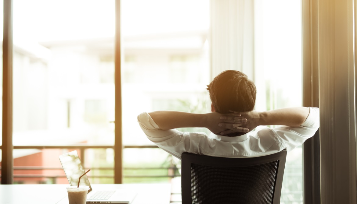 executive sitting back with his hands behind his head