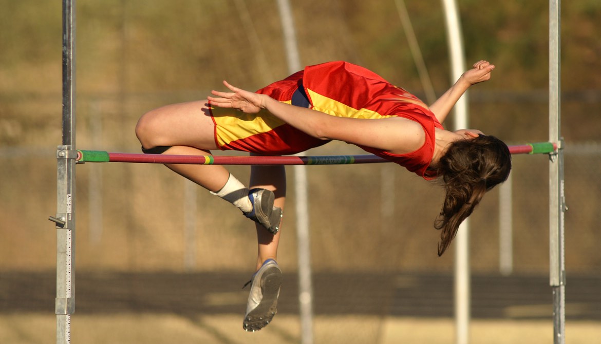 high jumper clearing the raised bar