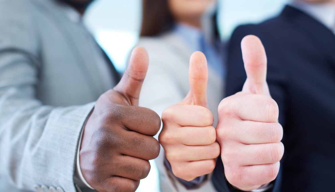 three executives of diverse ethnicities with their thumbs up