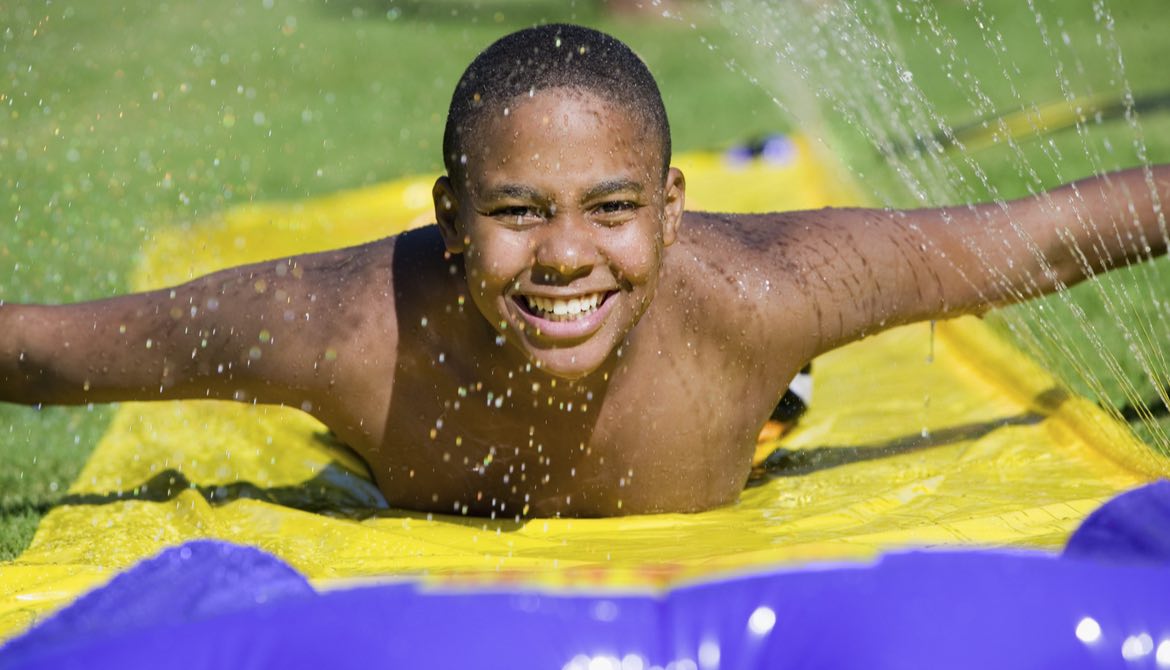 boy playing on slip n slide