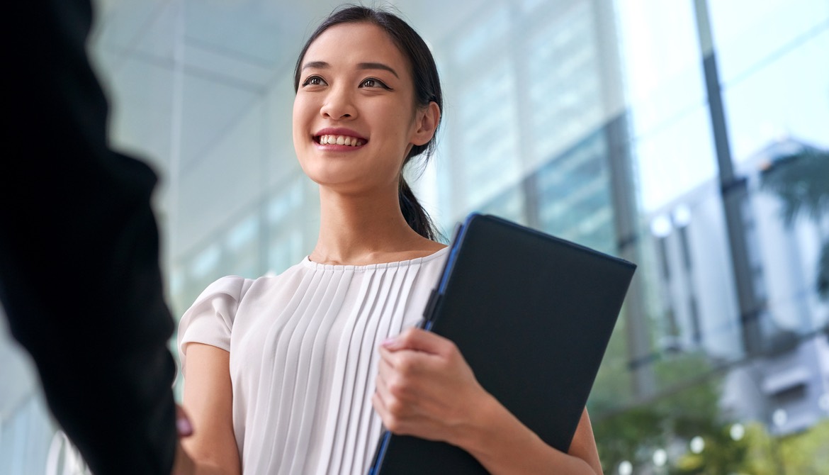 young smiling businesswoman shaking hands after negotiating promotion or job interview