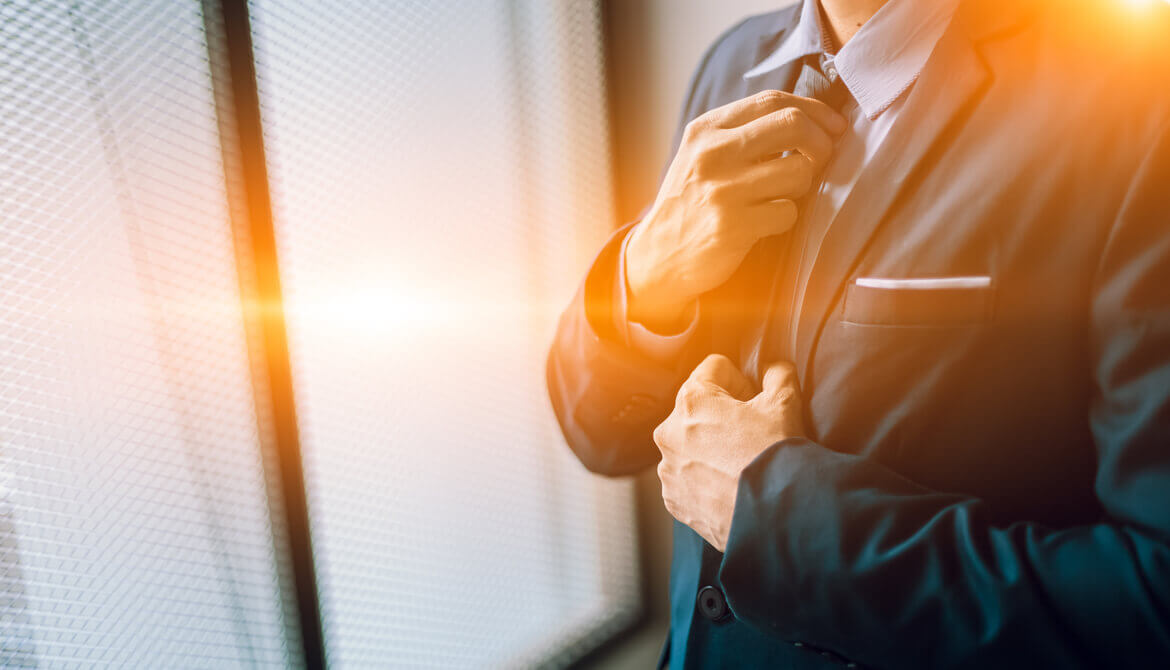 male executive adjusts his tie