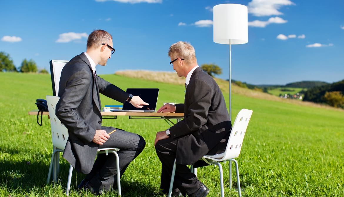 business men meeting outside with table, laptop and lamp