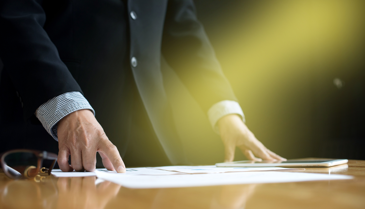 executive standing at table in spotlight