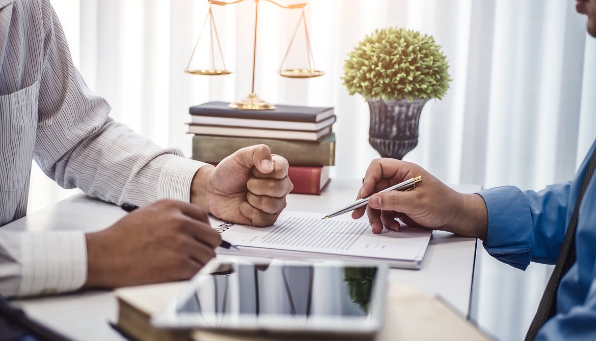 two executives with paperwork and legal scales