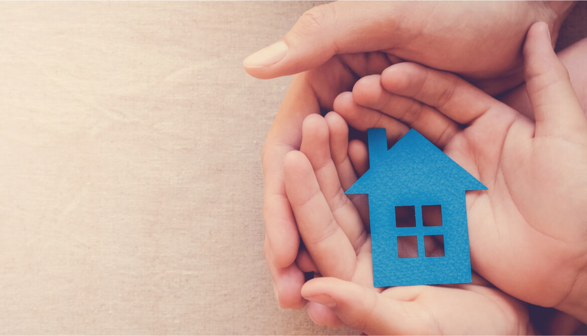 adult and kid hands hold blue paper house