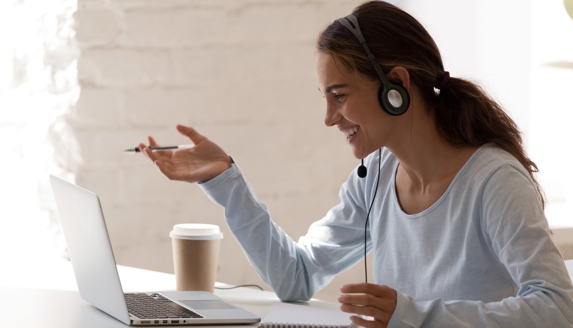 woman smiling using laptop to meet 