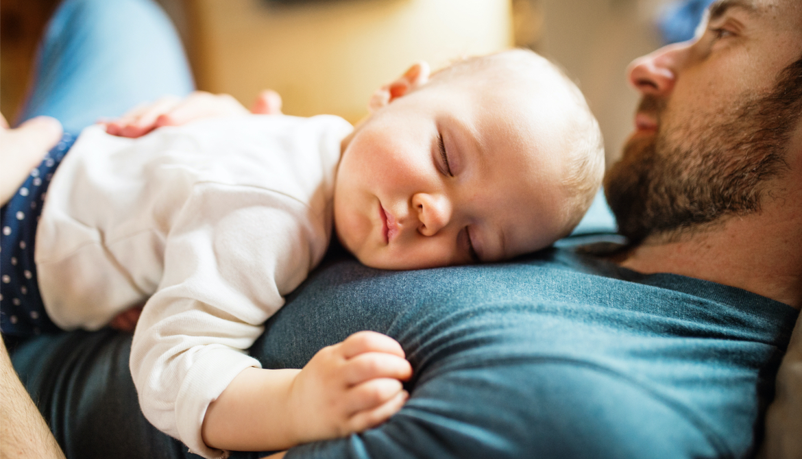 baby sleeps on her father's chest