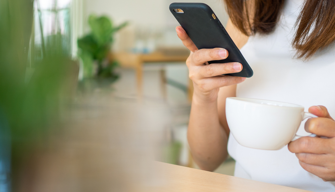 woman drinking coffee with smartphone