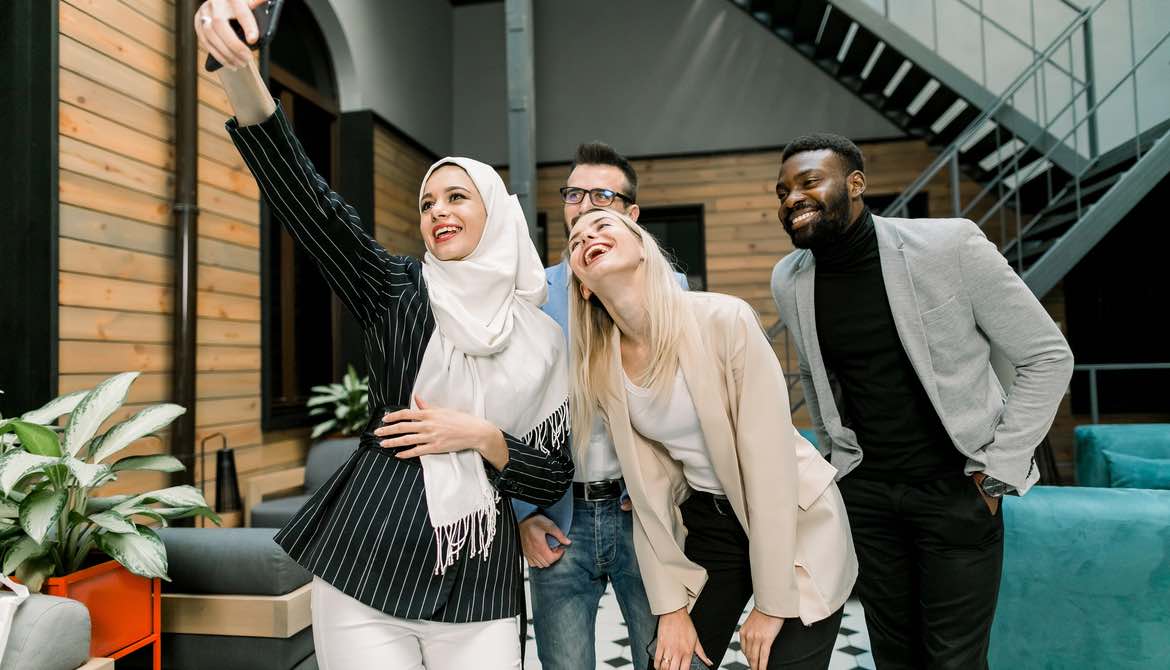 a diverse work team takes a selfie