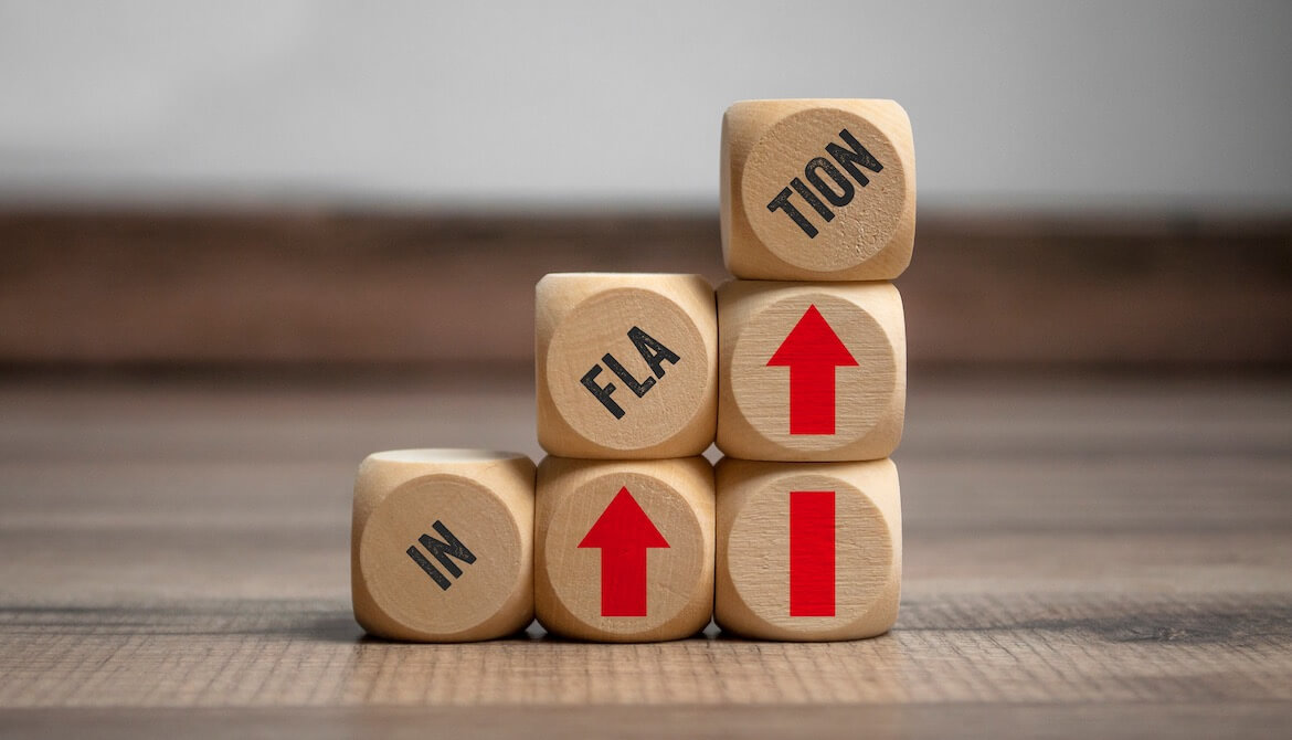 wooden blocks with up arrows and word inflation stacked into a staircase