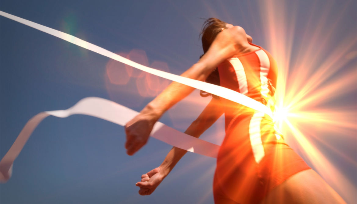 runner breaks the finish line tape