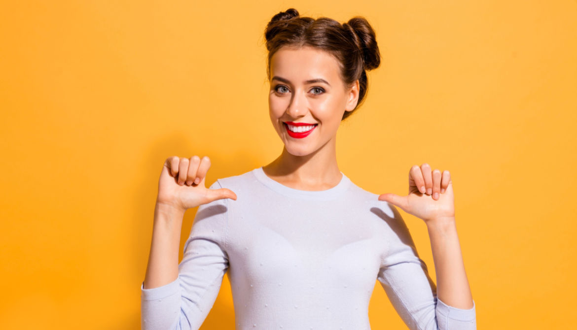 woman in pig tails with thumbs to self