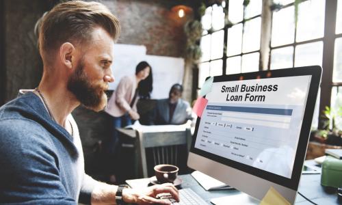 man looking at business loan form on computer screen