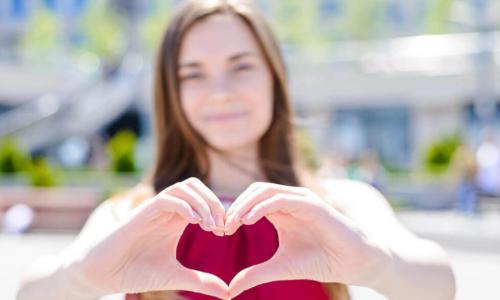 girl makes a heart shape with her hands