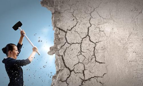 woman using sledgehammer to break down wall