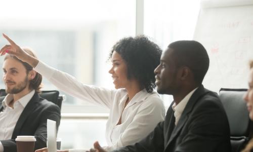 woman raising hand at meeting