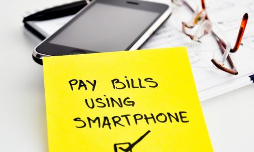 sticky note on smartphone saying pay using smart phone