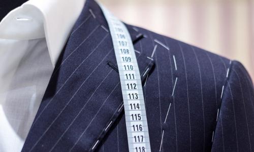 suit on mannequin with tailor’s marks and measuring tape