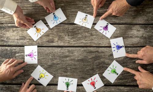 hands around cards with light bu.bs in different colors