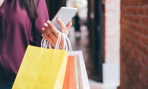 woman with shopping bags and smartphone