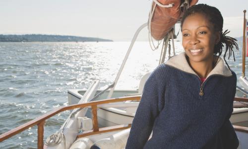 smiling African American woman sailing a sailboat