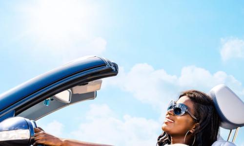 blue convertible car with smiling African American woman driver