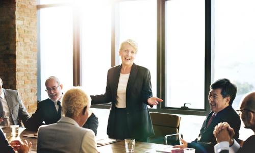 female board chair addresses directors during board meeting