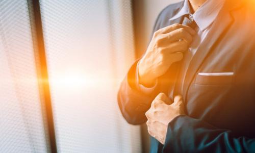 male executive adjusts his tie