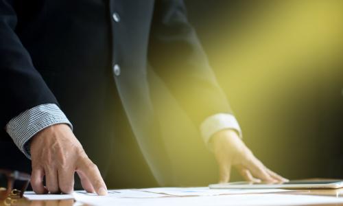 executive standing at table in spotlight