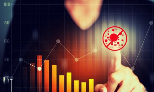 businesswoman points at glowing chart of transaction data with COVID-19 coronavirus image