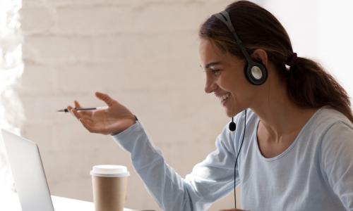 woman smiling using laptop to meet 