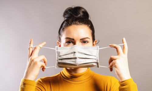 Woman puts on face mask