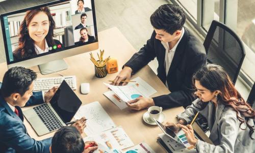 conference call with female leader on computer screen at the table