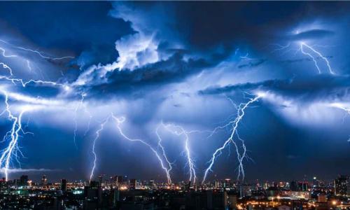 Lightning storm over city in purple light