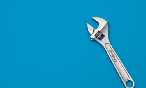 silver wrench on blue background 