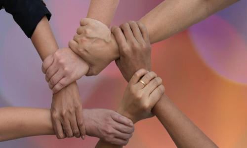 diverse people putting their hands together